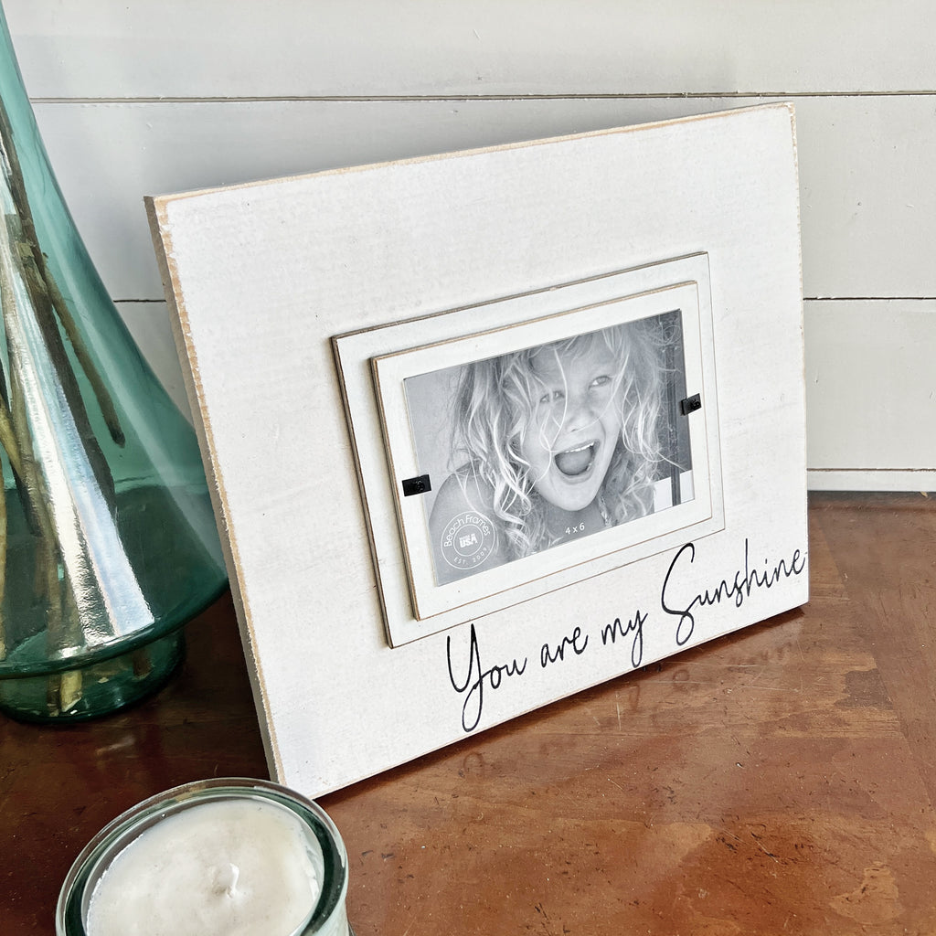 http://beachframes.com/cdn/shop/products/you_are_my_sunshine_picture_frame_sign_white_decor_2_1024x.jpg?v=1674224200